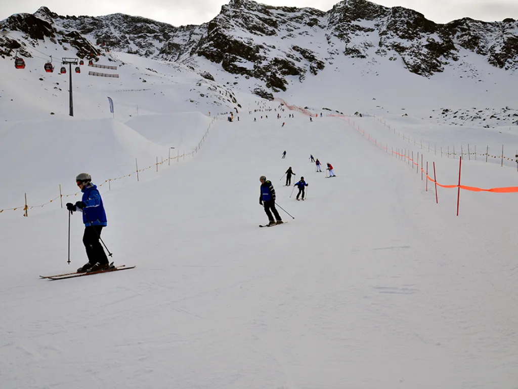 Skifahrende auf der Piste an der Absperrung.